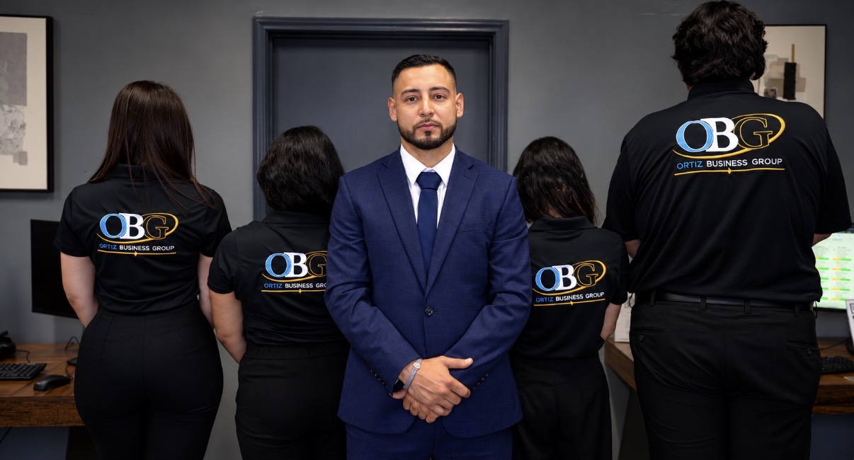 The Ortiz Business Group team standing together in our office